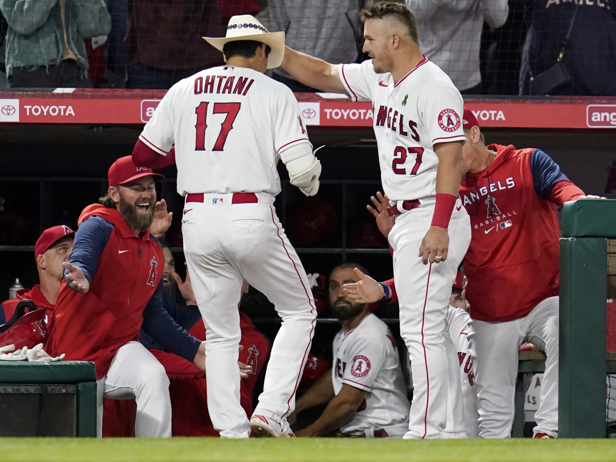 Los Angeles Angels center fielder Mike Trout (27) places a cowboy hat on the head of designated hitter Shohei Ohtani (17) after Ohtani hit a home run during the sixth inning of a baseball game against the Tampa Bay Rays in Anaheim, Calif., Monday, May 9, 2022.